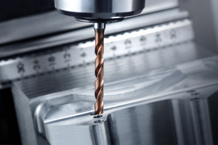 Drill in action on a metal component, focus on the metal machining