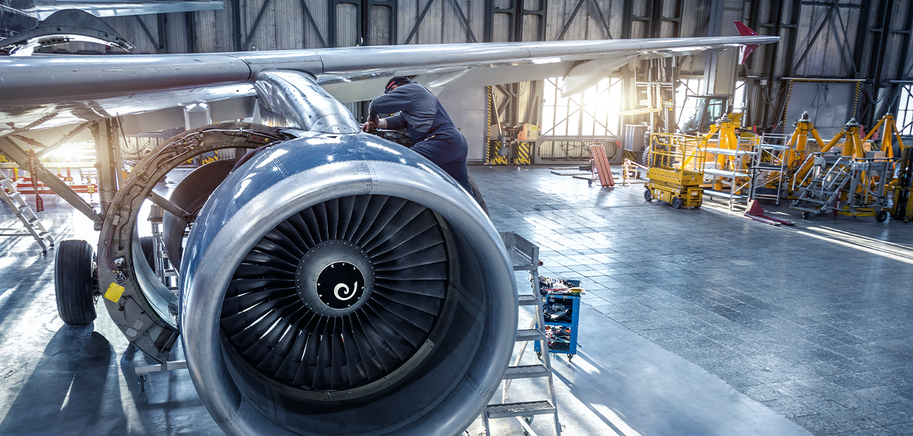 Flugzeugmechaniker bei der Wartung eines Triebwerks in einer Flugzeughalle