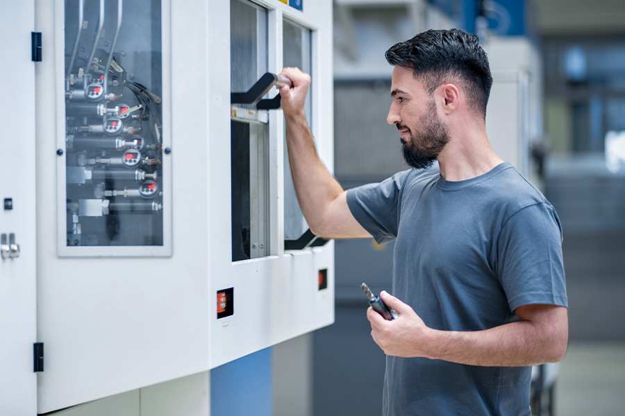 Skilled labourer operating CNC machine for tool production