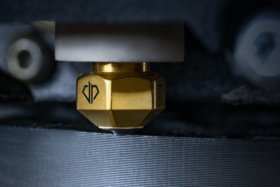Close-up of a 3D printing nozzle with the DIANOZ logo