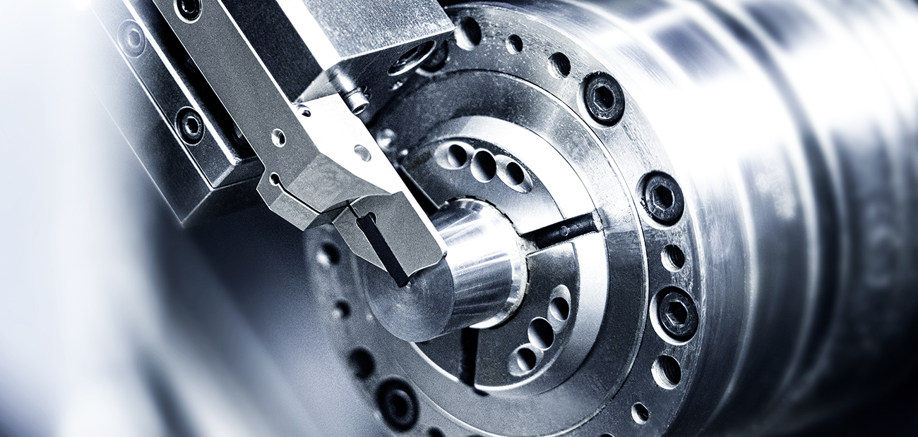 Das Bild zeigt eine dynamische Szene in einer Fertigungs- oder Werkstattumgebung, in der ein Einstechwerkzeug auf ein rotierendes Metallstück einwirkt Das Bild zeigt eine dynamische Szene in einer Fertigungs- oder Werkstattumgebung, in der ein Einstechwerkzeug auf ein rotierendes Metallstück einwirkt