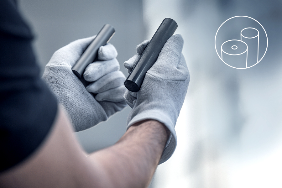 Arbeiter prüft zwei zylindrische Hartmetallstäbe