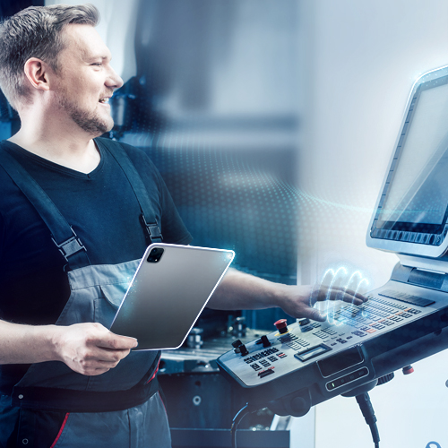 Techniker bedient CNC-Maschine mit einem Tablet in der Hand