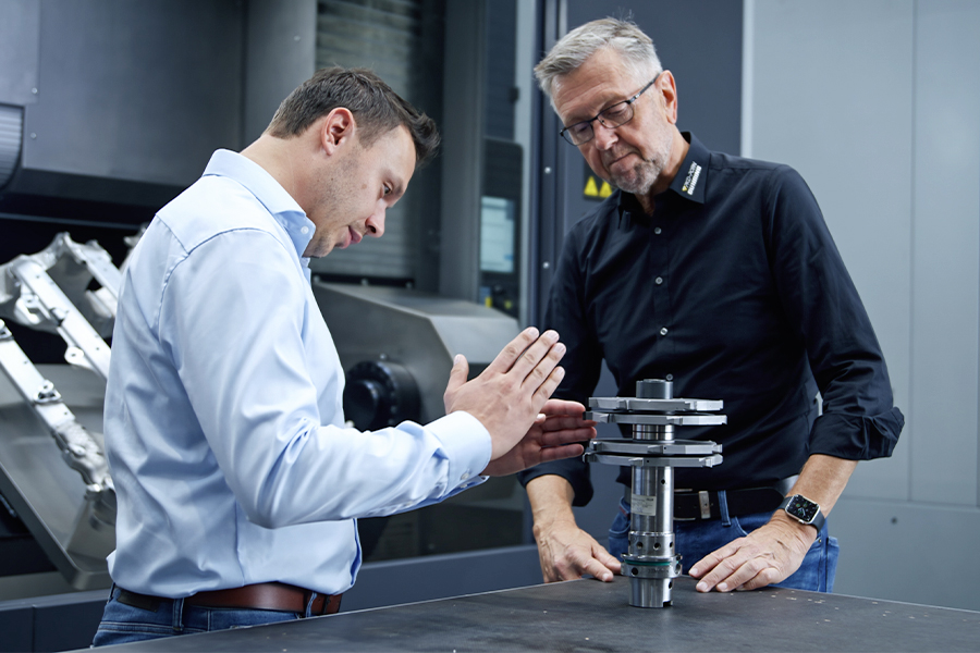 Two technicians in discussion about a machine component in the production area
