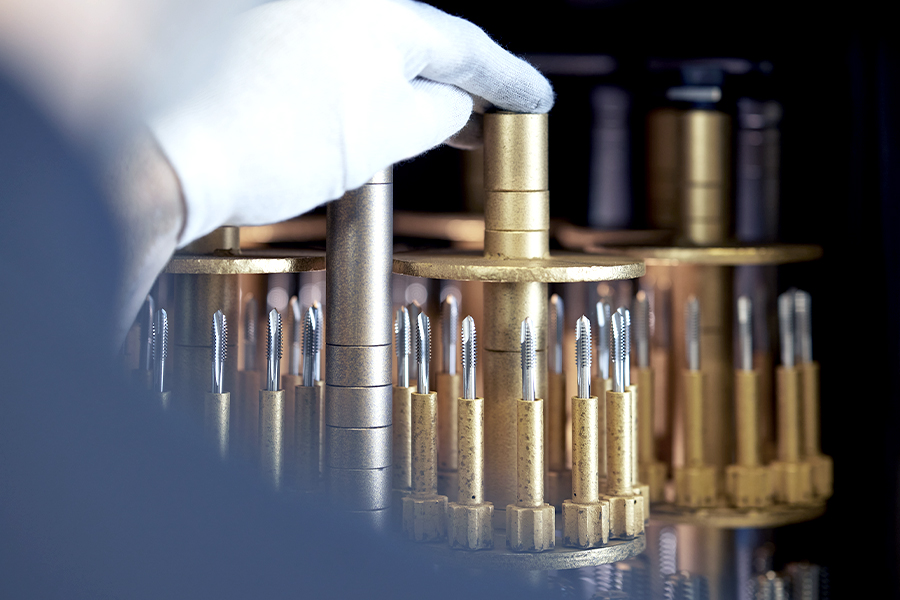 Employees inspects precisely coated precision tools
