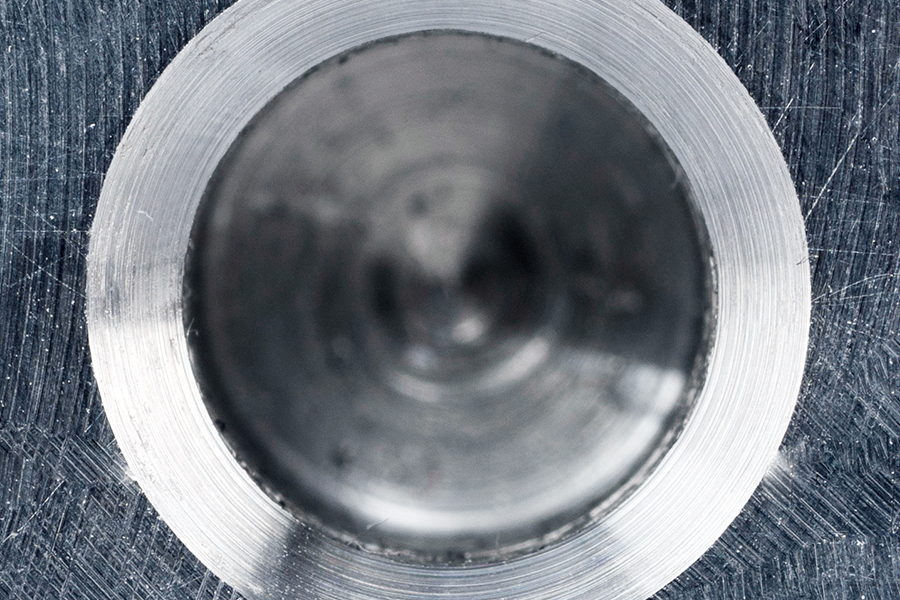 Macro photograph of a machined drill hole with visible turning marks