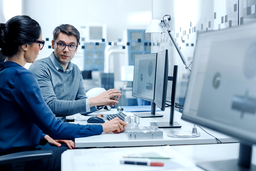 Employees discuss CAD drawings and cutting data
