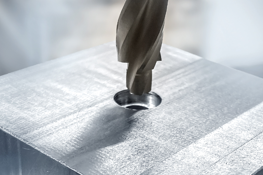 A countersink is used to countersink a metal hole in a solid metal block.