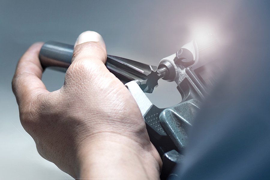 Employee handling a reamer with precision at a workbench