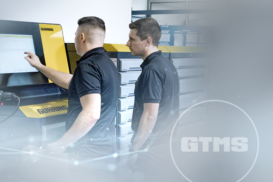 Two technicians in front of a tool management system; one of the technicians is operating a touch screen