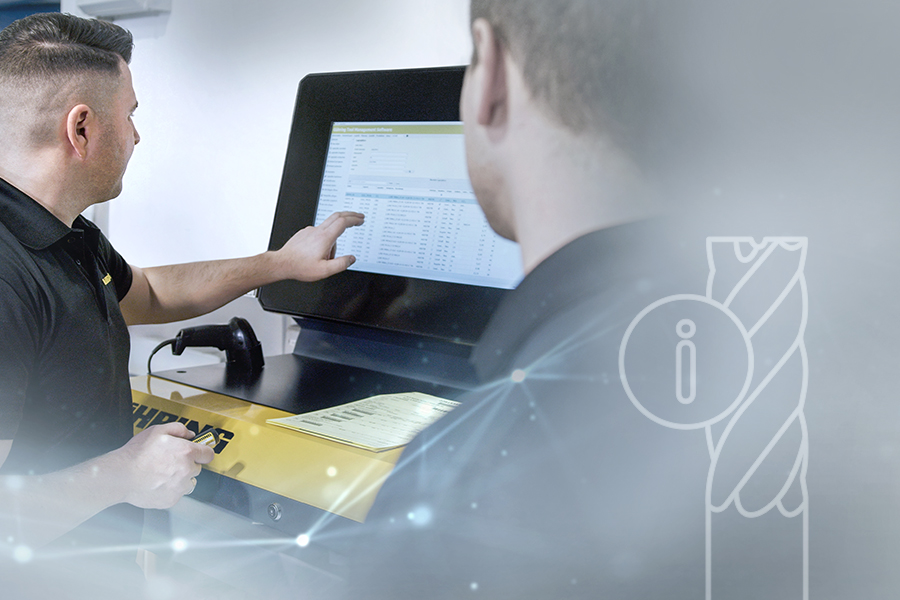 Two employees interact with a yellow tool dispensing machine