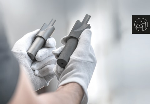 Ein Mitarbeiter hält zwei Hartmetall-Rohlinge in den Händen