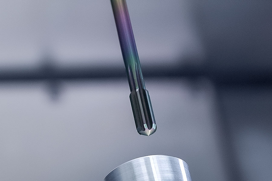 Close-up of a reamer HR 500 AL machining an on-tank valve of a fuel cell, illustrated next to a specified product description on an information sheet