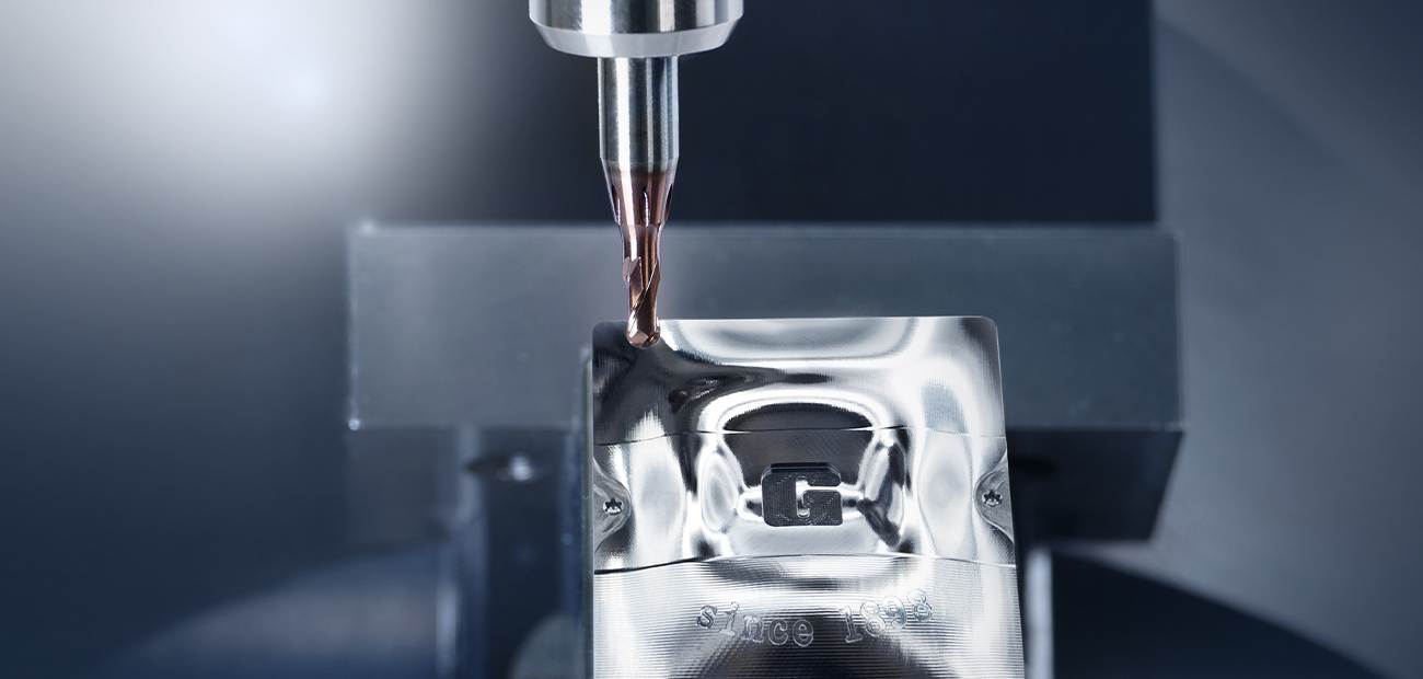 Hochpräzise Metallbearbeitung mit einem modernen CNC-Werkzeug, das eine glänzende Metallkomponente mit dem Logo 'G-Mold' bearbeitet.
