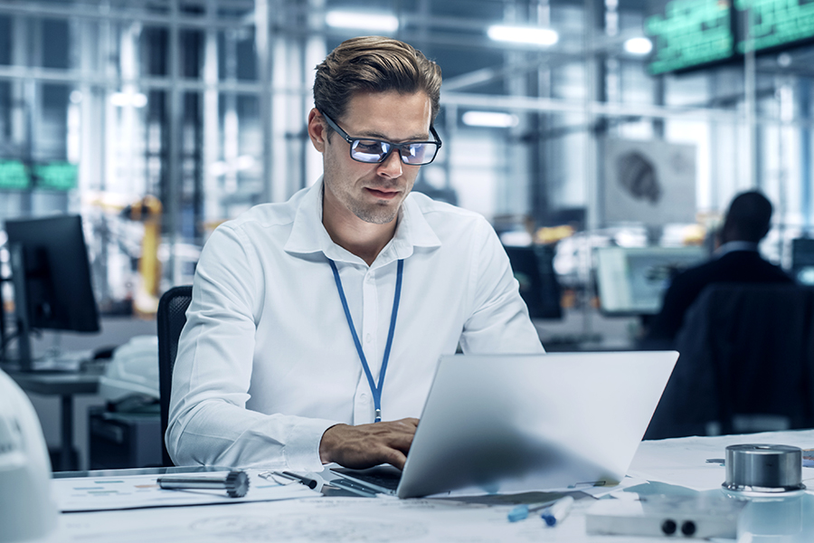Mitarbeiter am Laptop nutzt Zerspanungs-Wiki in einem modernen Büro zur Verbesserung der Produktionsprozesse Mitarbeiter am Laptop nutzt Zerspanungs-Wiki in einem modernen Büro zur Verbesserung der Produktionsprozesse