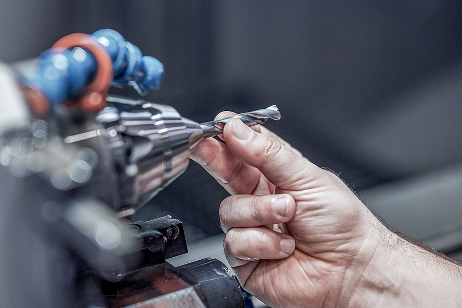 Specialist for tool refurbishment checks the sharpness of a twist drill