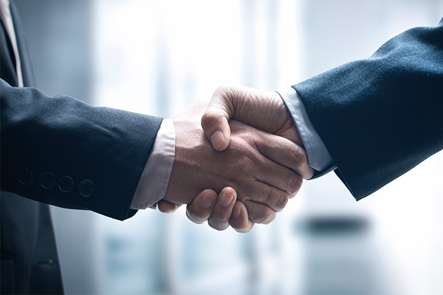 Two businessmen in suits shake hands
