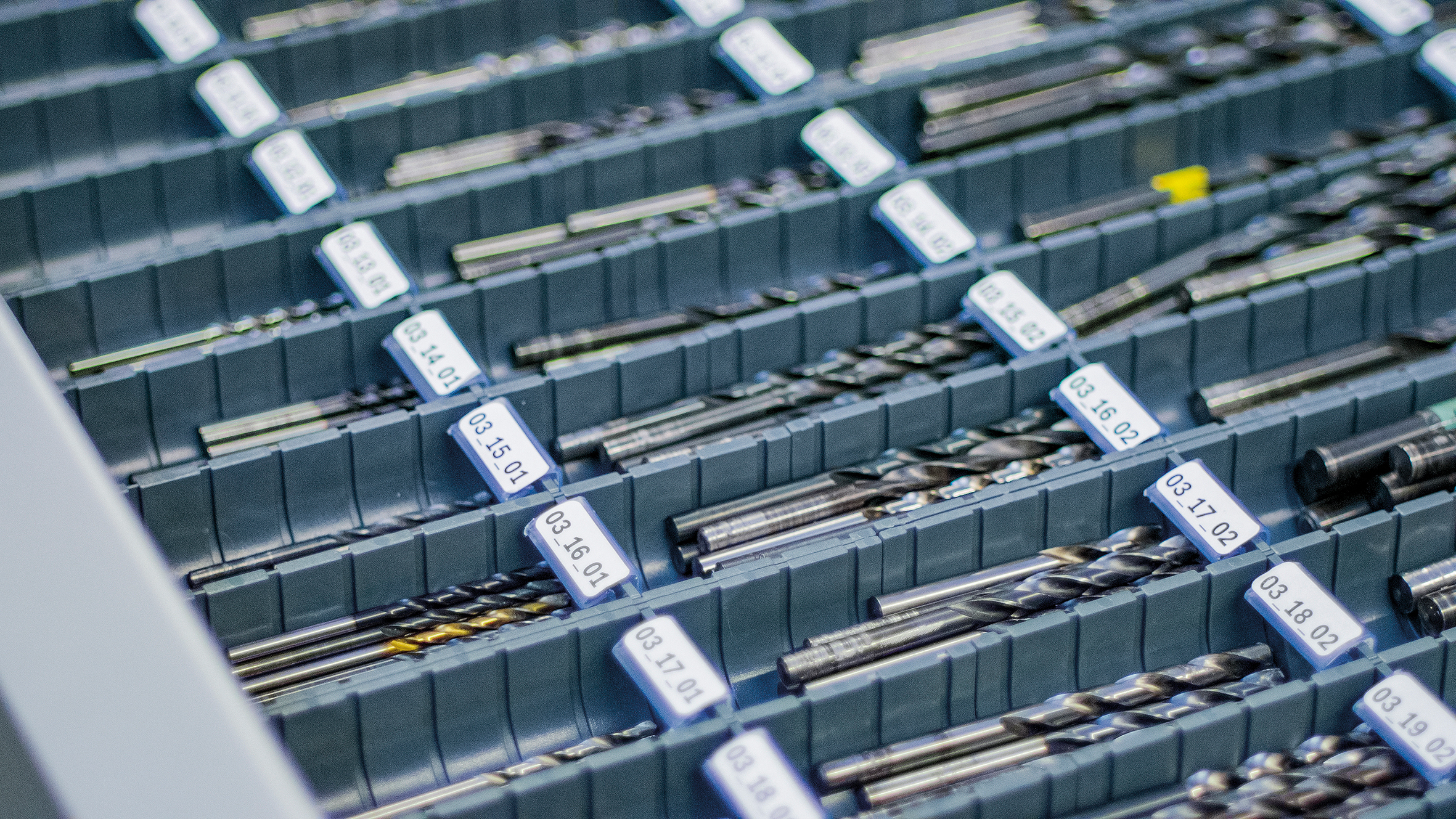 In einer geöffneten Schublade im Werkzeugschrank liegen geordnet verschiedene Bohrer
