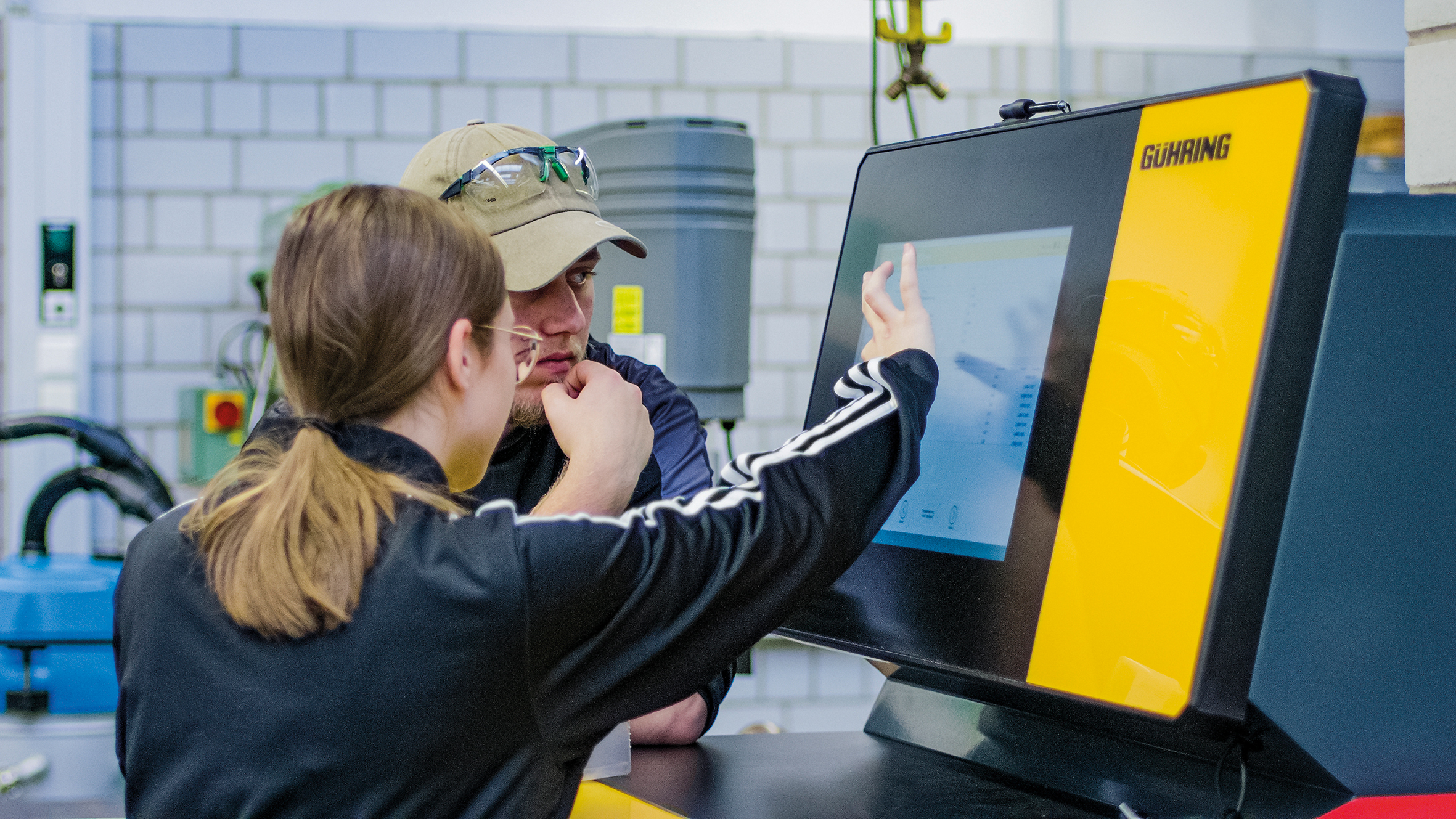 Eine Schülerin bedient den Monitor des Werkzeugschranks.